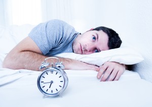 man in bed with eyes opened suffering insomnia disorder